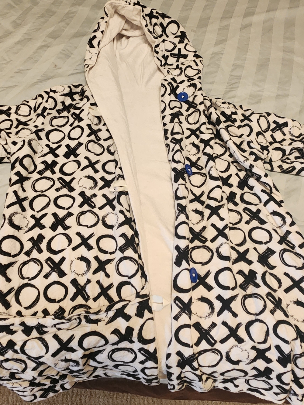 This unique hooded robe features a striking black and white 'XO' (Hugs and Kisse